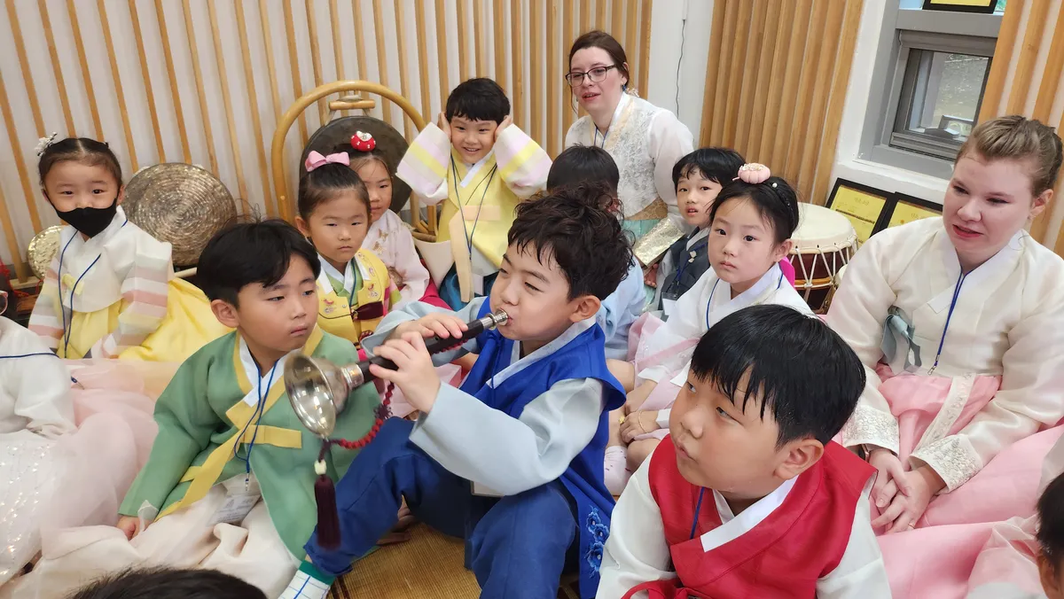 태평소를 불고 있는 유치원 수강생들과 같이 즐거워하는 아이들 사진