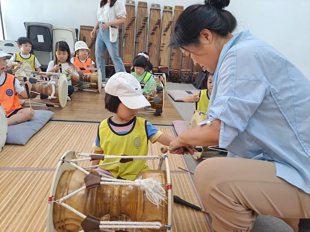 유치원 수강생에게 장구잡는법을 알려주고 있는 송리결 선생님