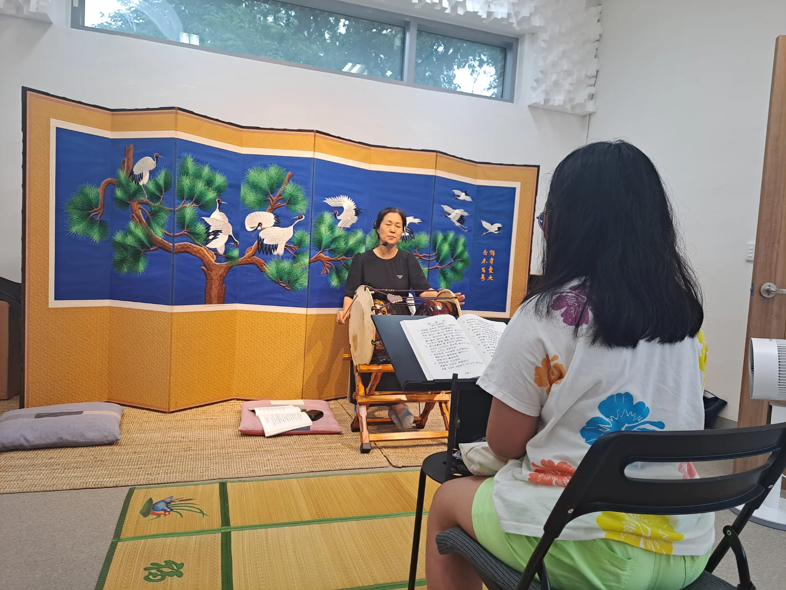 전공반 수강생이 진지한 눈빛으로 원장님 앞에서 소리 연습에 집중하는 장면